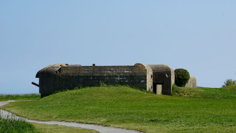 Betonbunker mit Kanonenrohr in einer Wiesenlandschaft, Batterie-de-Longues