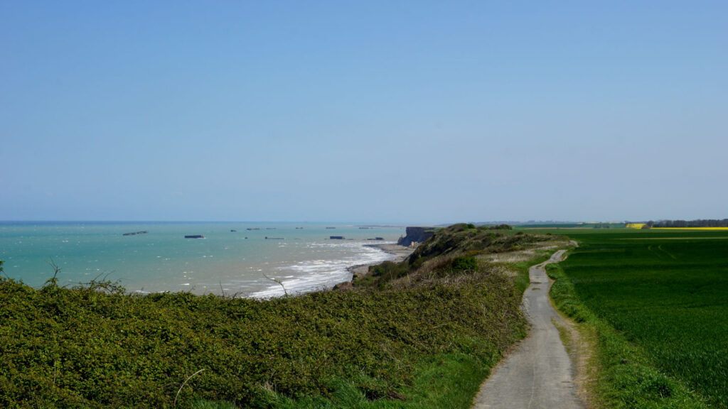 Aussicht auf viereckige Betonblöcke im Meer vor der Küste, die Reste des künstlichen Hafens aus dem 2. Weltkrieg