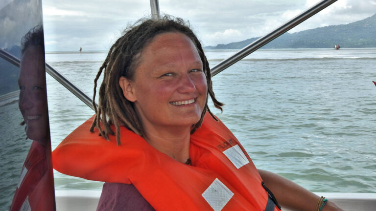 Frau mit Dreadlocks und Schwimmweste auf einem Boot