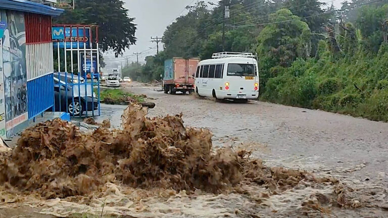 braune Wassermassen sprudelt auf eine Straße mit stehenden Fahrzeugen