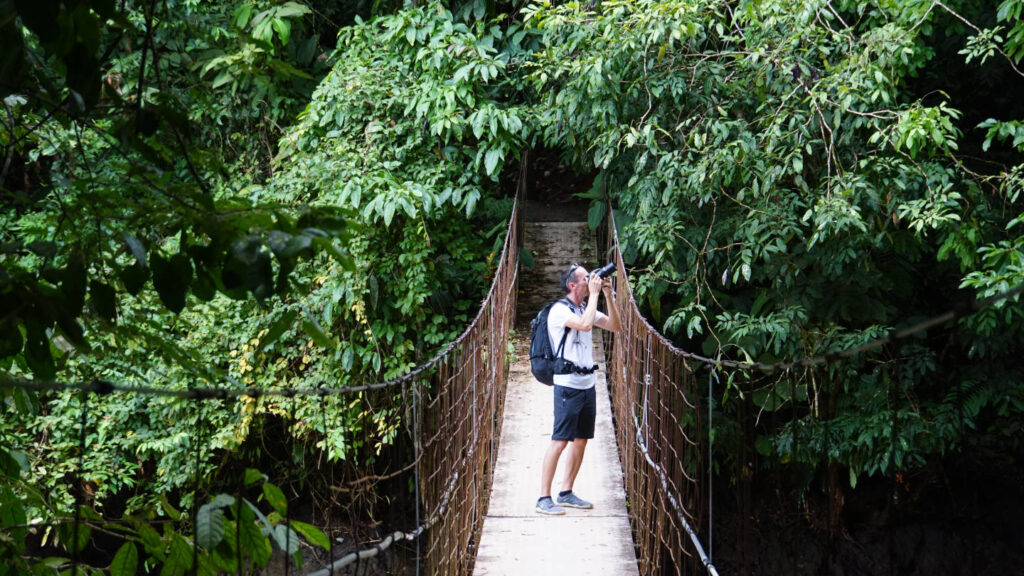 Mann beim fotografieren auf einer Hängebrücke