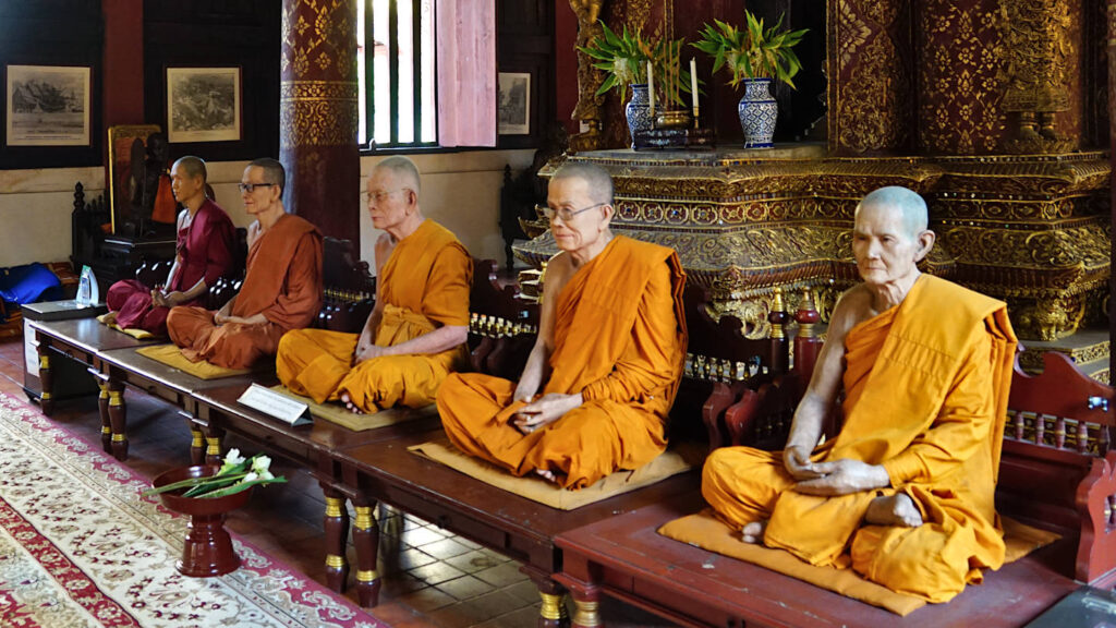 Wachsfiguren von buddhistischen Mönchen in Gebetsstellung im Wat Phra Singh, Chiang Mai, Thailand