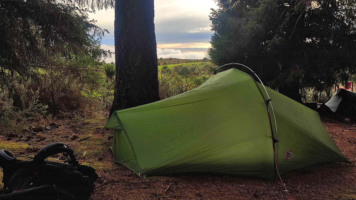 grünes Trekkingzelt im Wald bei Sonnenuntergang am Trekkingplatz Estanquinhos auf der Insel Madeira